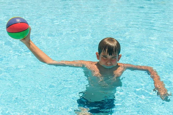 Niño con una pelota en la piscina — Foto de Stock