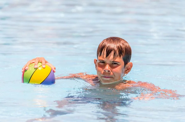 Niño con una pelota en la piscina — Foto de Stock