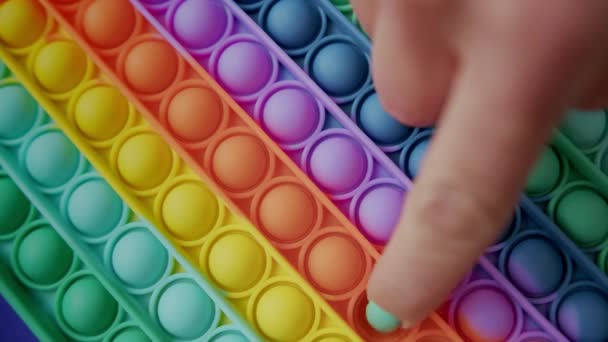 Dívka ruce hrát s Popit tlačit pop bublina Fidget hračka. Populární Vzdělávací Dětská hra Pop It s tlačítky a barevné anti-stresové hračky. — Stock video