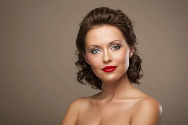 Gesicht einer schönen jungen brünetten Frau mit hellem Make-up und — Stockfoto