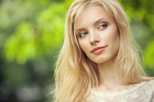 Bella giovane donna bionda su sfondo verde astratto — Foto Stock