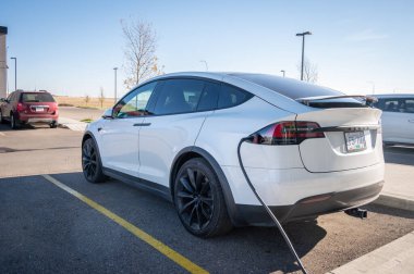 Medicine Hat, Alberta - 8 Ekim 2019: Tesla Model X elektrikli araba bir otelin bakım istasyonunda şarj ediliyor.