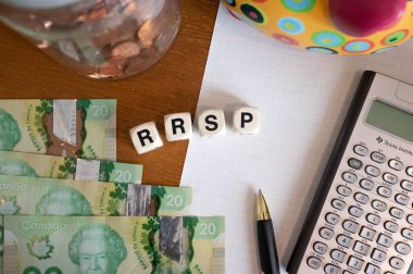 Calgary, Alberta - April 21, 2022: RRSP concept with canadian dollars, pen and calculator,