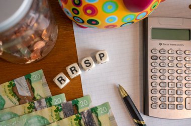 Calgary, Alberta - April 21, 2022: RRSP concept with canadian dollars, pen and calculator,