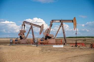 Dalum, Alberta - June 12, 2022: Pumpjacks working in the oil fields of Alberta on a spring day.