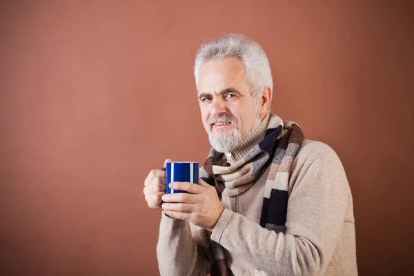 Sorrindo sênior em cachecol com um copo — Fotografia de Stock