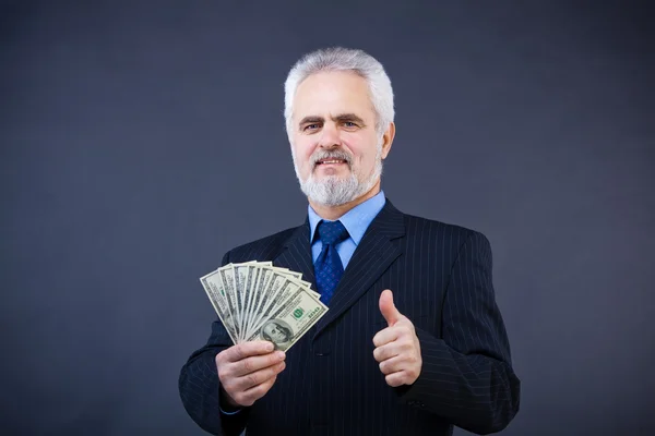 Business man holding cash and showing thumbs up — Stock Photo, Image