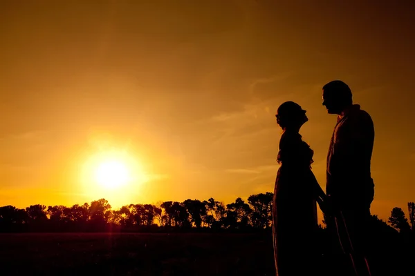 Amante casal no pôr do sol silhueta de fundo — Fotografia de Stock