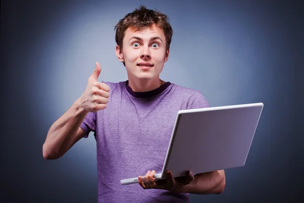 惊讶的笑容拇指起与笔记本电脑的男人 — 图库照片