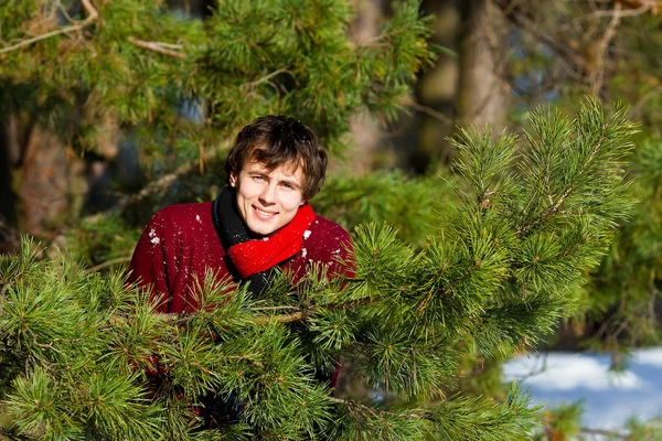 Jovem sorrindo na floresta de inverno — Fotografia de Stock