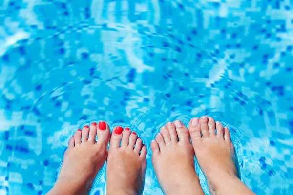 Women foot splashing in swimming pool — Stock Photo, Image