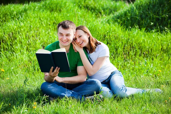 Amoureux dans le parc lisent le livre — Photo