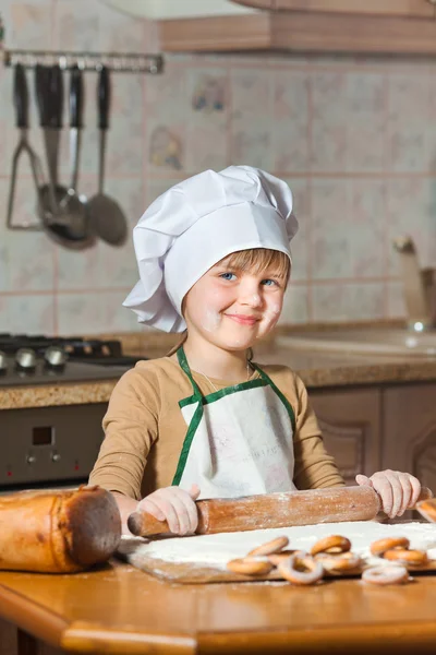 Bella ragazza con un cappello da chef che cucina dolce torta — Foto Stock