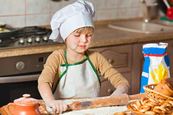 Schönes Mädchen mit Kochmütze, das süßen Kuchen kocht — Stockfoto