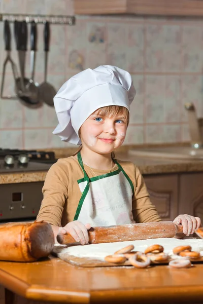 Мила дівчина в капелюсі шеф-кухаря готує солодкий торт — стокове фото