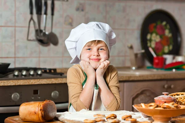 Chica encantadora en un sombrero de chef cocinar pastel dulce —  Fotos de Stock