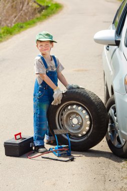 Çocuk tekerlek değiştirir