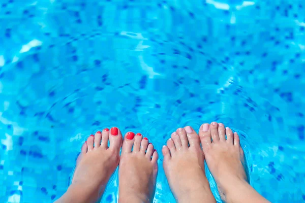 Sexy women legs splashing in swimming pool — Stock Photo, Image