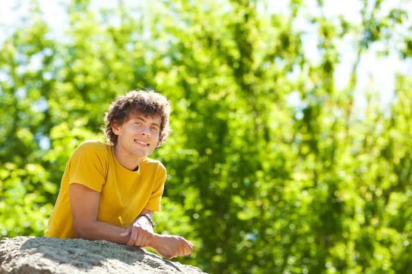 A young curly man in a forest — Stock Photo, Image