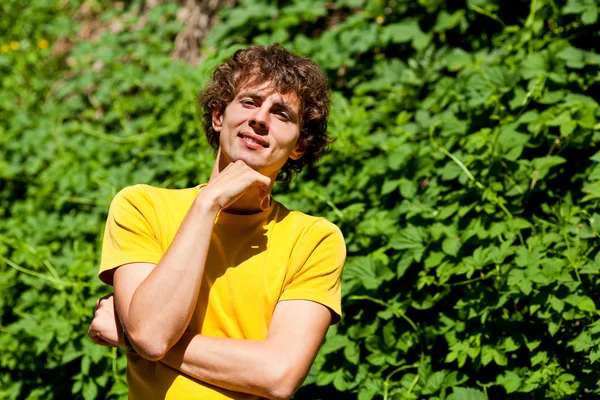 Un giovane uomo riccio in una foresta — Foto Stock