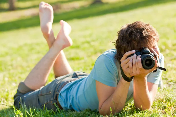 Человек с фотоаппаратом в парке — стоковое фото