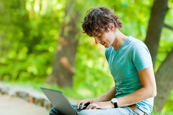 Homem feliz com um laptop ao ar livre — Fotografia de Stock