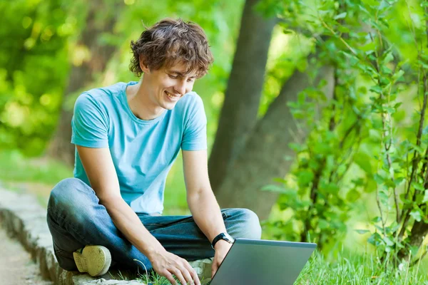 Homem feliz com um laptop ao ar livre — Fotografia de Stock