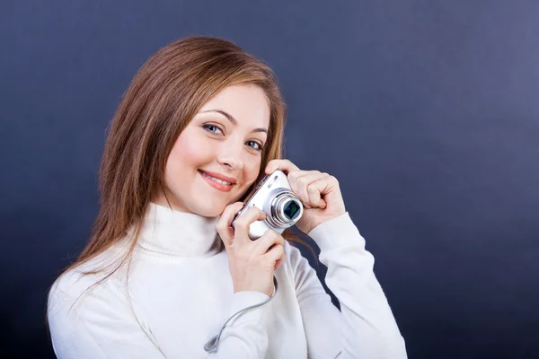 Beautiful girl with a photo camera on a dark blue background — Stock Photo, Image