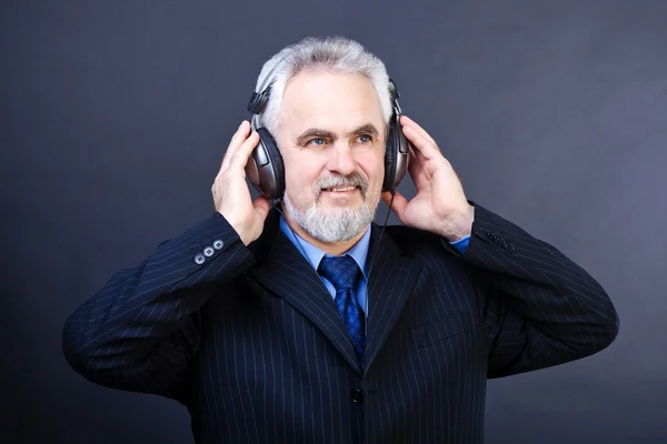 Studio shot of business man with headphones listening music on Stock Image