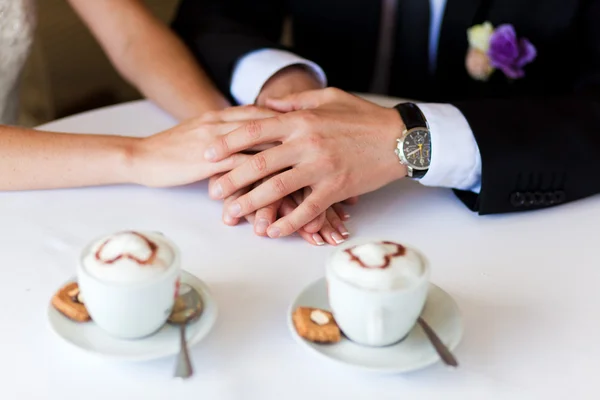 Dłonie mężczyzny i kobiety na stole w kawiarni — Zdjęcie stockowe