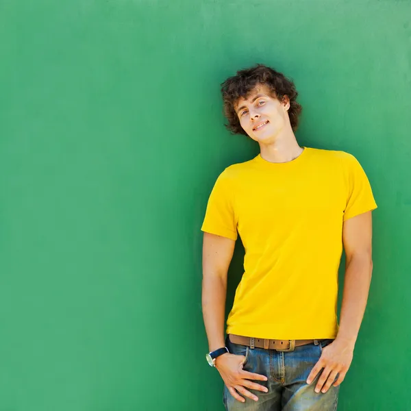 Homem com cabelo encaracolado em uma camiseta amarela Fotos De Bancos De Imagens