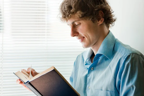 Молодой бизнесмен с интересной книгой — стоковое фото