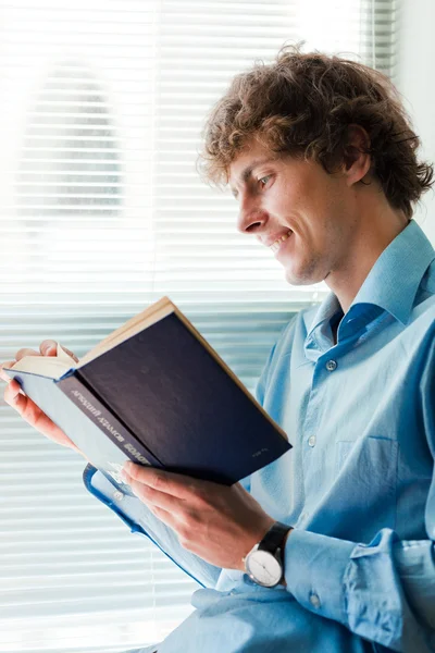 Young businessman with interesting book — Stock Photo, Image