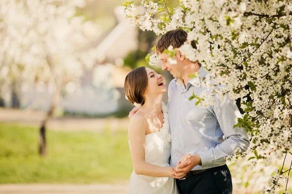 Portrait of young loving couple in flowering park — Stock Photo, Image