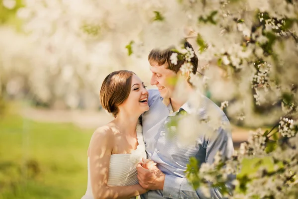 Portrait of young loving couple in flowering park — Stock Photo, Image