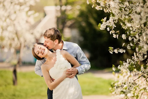 Portrait of young loving couple in flowering park — Stock Photo, Image