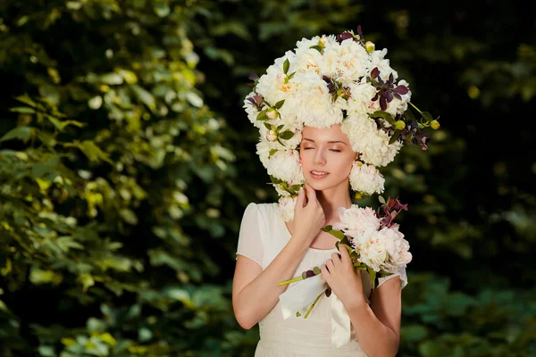 Красивая молодая девушка с шапкой цветов на голове — стоковое фото