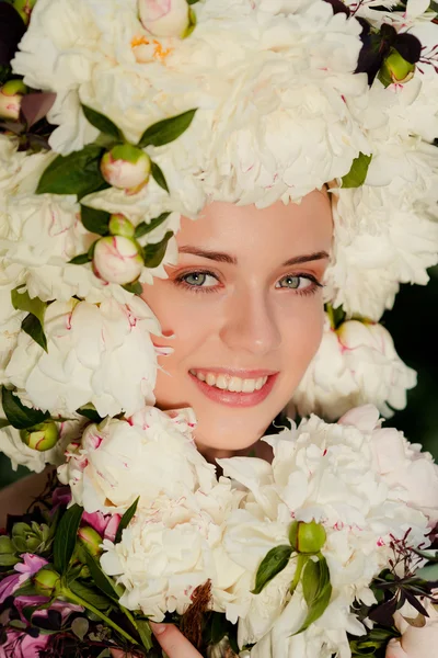 Beautiful young girl with a cap of flowers on her head — Stock Photo, Image