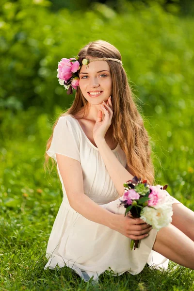 Menina bonita com buquê de flores ao ar livre — Fotografia de Stock