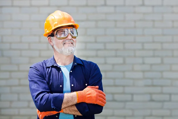 Portrait of happy seniorman with hard hat Posing with crossed ar