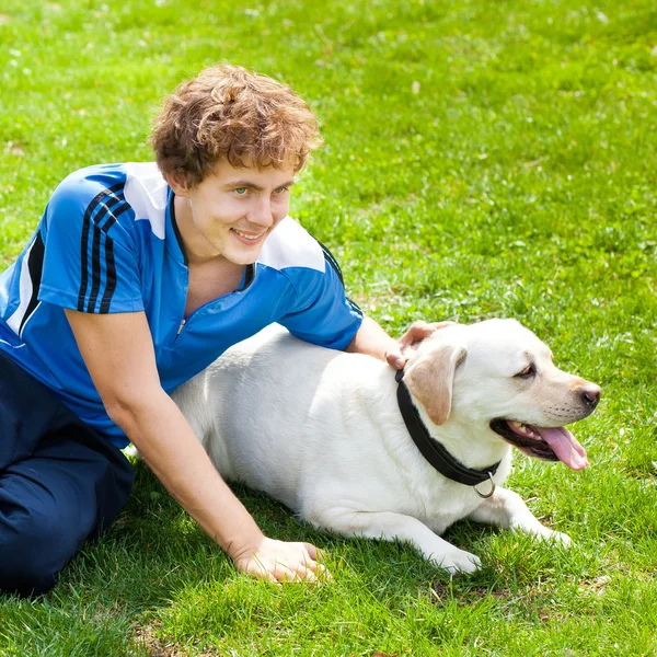 Glimlachende man met zijn hond liggen buiten curl — Stockfoto