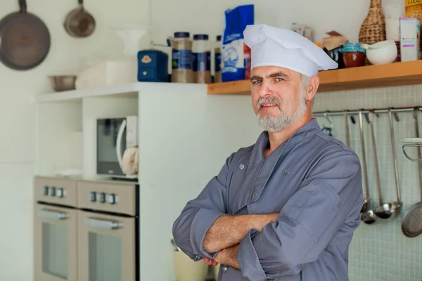 Vriendelijke chef-kok glimlachend op zijn keuken — Stockfoto