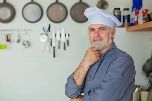 Vriendelijke chef-kok glimlachend op zijn keuken — Stockfoto