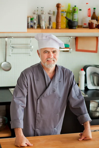 Chef amable sonriendo en su cocina — Foto de Stock