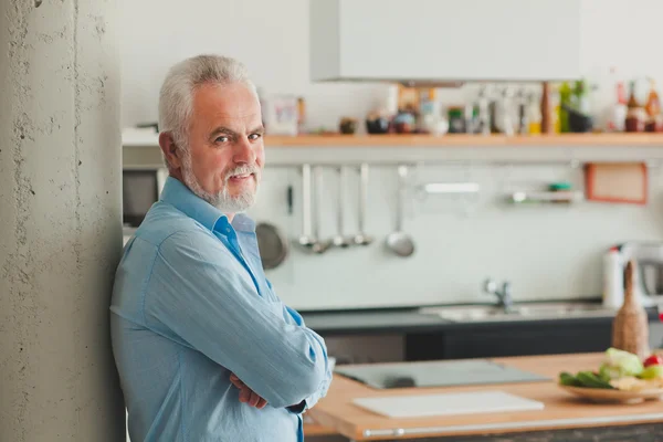 Senior man in zijn keuken — Stockfoto