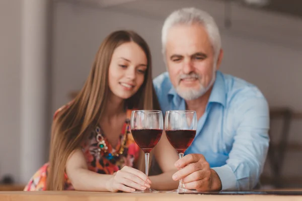Jovem menina e homem sênior segurando vinho glasess — Fotografia de Stock