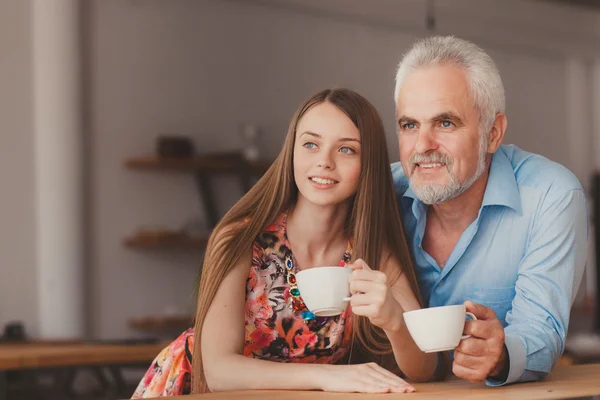 Uomo anziano con bere cofee con bella donna — Foto Stock