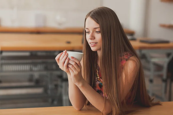 Beautiful young woman drinking coffee in the kitchen Stock Image