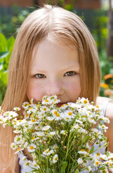 Little girl with a bunch of daisies — Stock Photo, Image