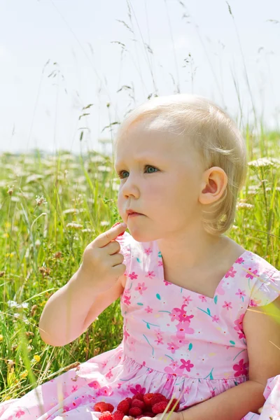 Little girl eating raspberries — Stock Photo, Image